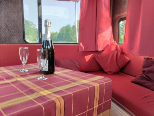 a bottle of wine sitting on a table with two glasses at Peniche Maryjeanne in Gannay-sur-Loire