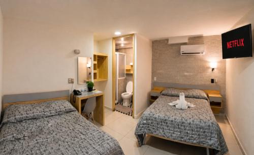 a hotel room with two beds and a bathroom at El Suburbio - Morelos Sur in Morelia