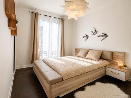 a bedroom with a bed with birds on the wall at Appartement 2 pieces cosy proche Paris et metro wifi rapide arrivee autonome in Asnières-sur-Seine