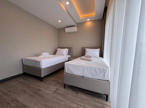 two beds in a small room with white walls at Albera Villas in Kemer