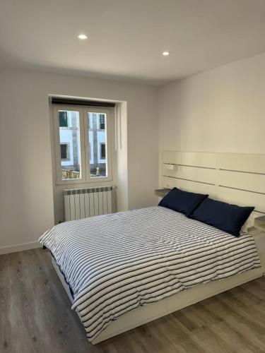 a white bedroom with a large bed with blue pillows at Cabalo Holiday Inn in Tui