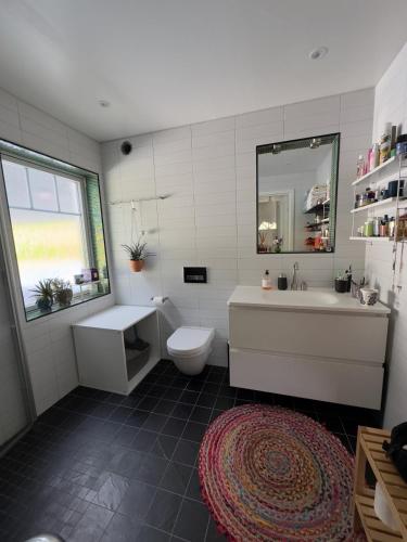 a bathroom with a tub and a toilet and a sink at Beautiful pool villa with stunning ocean view in Tyresö