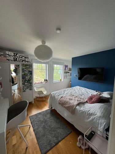 a bedroom with a blue wall and a bed at Beautiful pool villa with stunning ocean view in Tyresö
