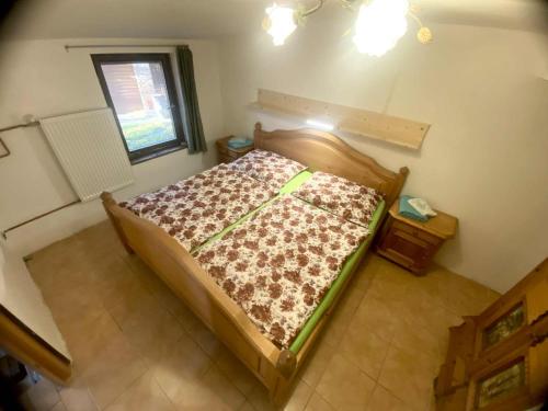 a small bed in a room with a window at Chaloupka na Kalovech in Sušice