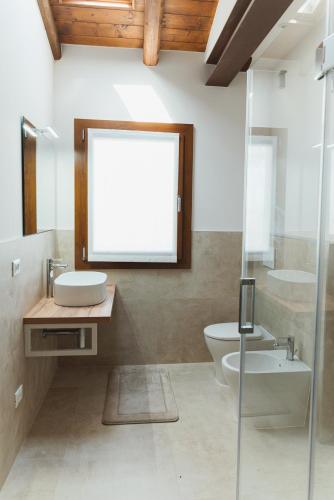 a bathroom with a sink and a toilet and a mirror at Villa Codetta Chalet Caterina in Boccatossa