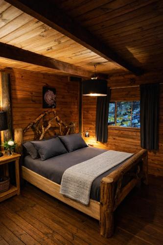 ein Schlafzimmer mit einem Bett in einem Zimmer mit Holzwänden in der Unterkunft El Rincon Eco Hotel in Los Ángeles
