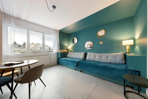 a bedroom with a blue bed and a table and chairs at Chez Guillaume in Bordeaux