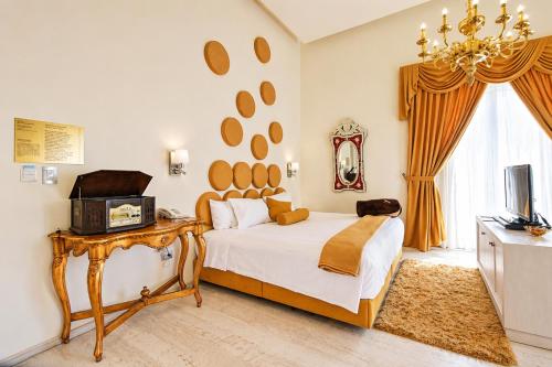 a bedroom with a large bed and a television at Hotel Andante in Puebla