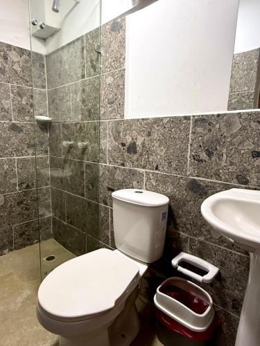 a bathroom with a toilet and a sink at Hotel Sol y Luna 2 in Medellín