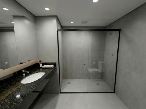 a bathroom with a glass shower and a sink at Viale Jardins in Foz do Iguaçu