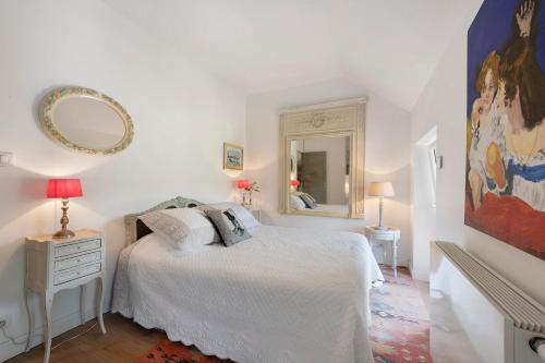 a white bedroom with a bed and a mirror at Au Fil De L'eau - Chambre d'hôtes in Guipavas