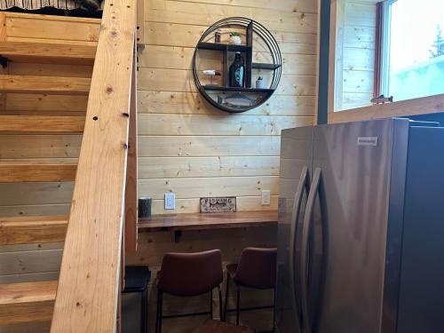 a kitchen with a refrigerator and a wooden wall at Catch'em AK - Trout Haven in Soldotna