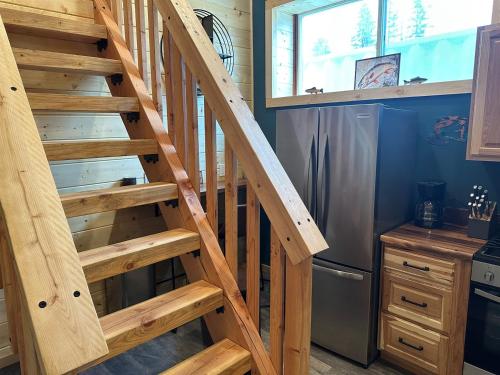 a wooden staircase in a kitchen next to a refrigerator at Catch'em AK - Trout Haven in Soldotna