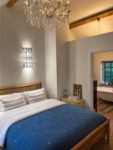 a bedroom with a large bed and a chandelier at The little Hotel-luxury home in Motcombe