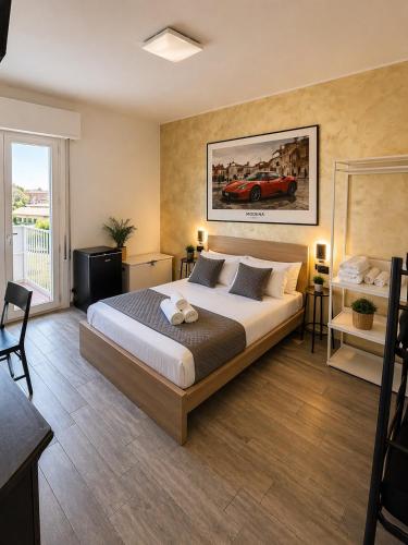 a bedroom with a bed with a car on the wall at Modena Station - Suite H24 in Modena