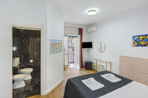 a bedroom with a bed and a bathroom with a toilet at Mirosa Luxury Rooms in Pompei