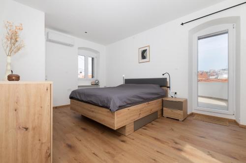 a bedroom with a bed and a large window at Amare in Mali Lošinj