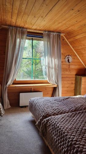 a bedroom with a bed and a window at Forest Sulimówka - dom na wyłączność z dala od sąsiadów in Ruda Kameralna