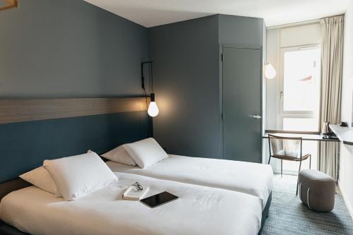 a hotel room with two beds with a tray on it at Kyriad Metz Centre - Restaurant Moze in Metz