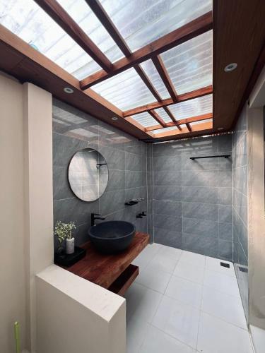 a bathroom with a black sink and a skylight at Ananda Uthaan in Sreemangal