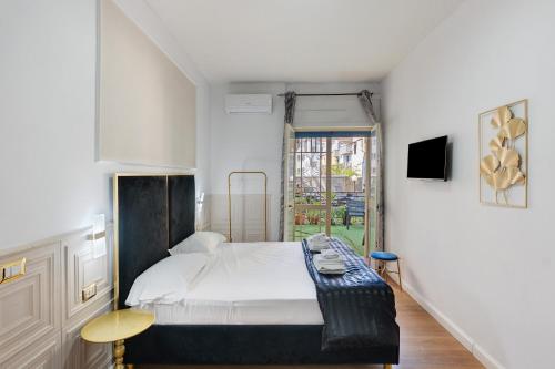 a small bedroom with a bed and a tv at Mirosa Luxury Rooms in Pompei
