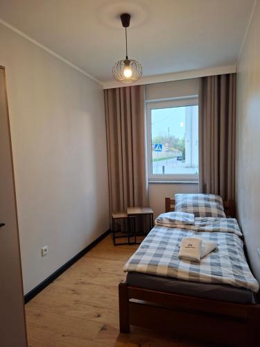 a bedroom with a bed and a window at Apartament 3 - OpolskieNoclegi in Krapkowice