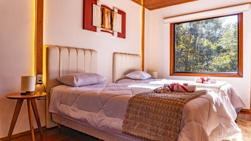 a bedroom with a large bed with a window at Invernada Blessmann - Hotel Fazenda in Vespasiano Corrêa