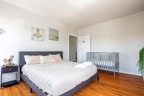 a bedroom with a large bed and a crib at Spacious 2BR-1BA-4 Beds NYC MetLife Parking in Bayonne