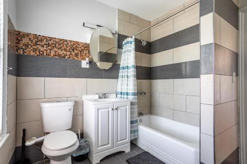 a bathroom with a toilet and a tub and a sink at Spacious 2BR-1BA-4 Beds NYC MetLife Parking in Bayonne