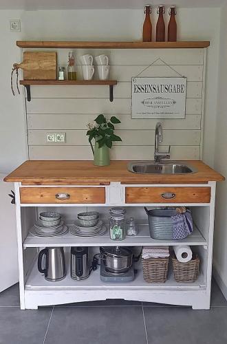 a kitchen with a sink and a shelf with dishes at Heimat in Karstädt