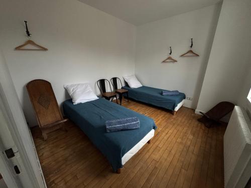 a room with two beds and a table and chairs at Gite La Forge in Rochecorbon