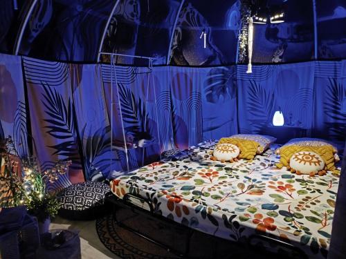 a bed with colorful pillows on it in a room at Cocoon Reflex'Ô in Escurolles