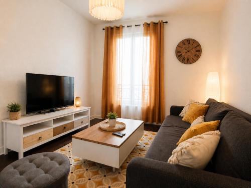 a living room with a couch and a tv at Appartement 2 pieces cosy proche Paris et metro wifi rapide arrivee autonome in Asnières-sur-Seine