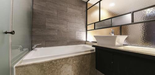 a bathroom with a white tub and a sink at 월호텔 in Pyeongtaek