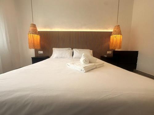 a bedroom with a large white bed with two lamps at Apartmento 3037 in Quarteira