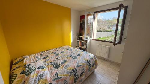 a bedroom with a bed and a window at L'Ombre du pommier in Paron
