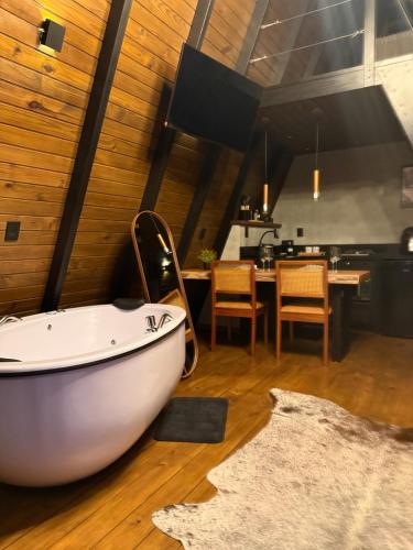 a bathroom with a white bath tub on a wooden floor at Cabanas Girassol in Venda Nova do Imigrante
