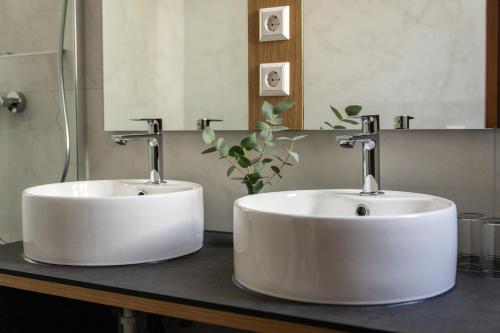 due lavandini bianchi su un bancone in un bagno di Hotel Boulevard a Costanza