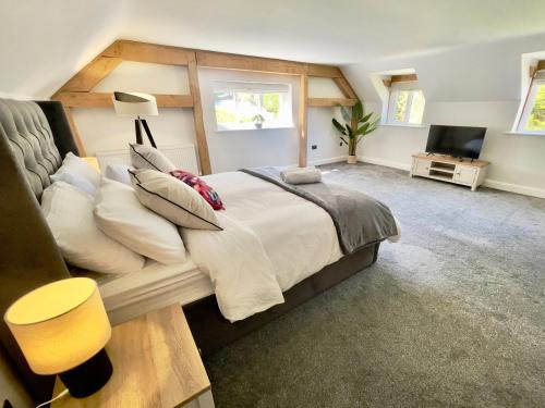 a bedroom with a large bed and a television at The Oaks in Blackburn