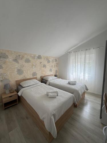 a bedroom with two beds and a window at Apartments Gašparić in Barbat na Rabu