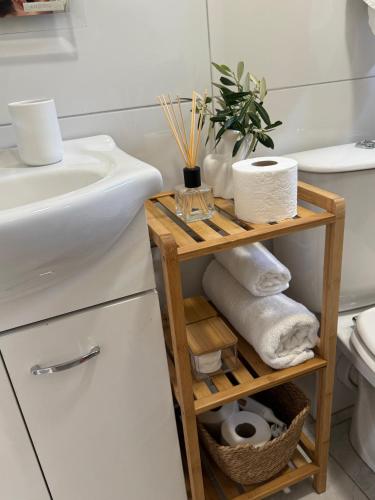 a bathroom with a sink and a shelf with towels at Apartments Gašparić in Barbat na Rabu