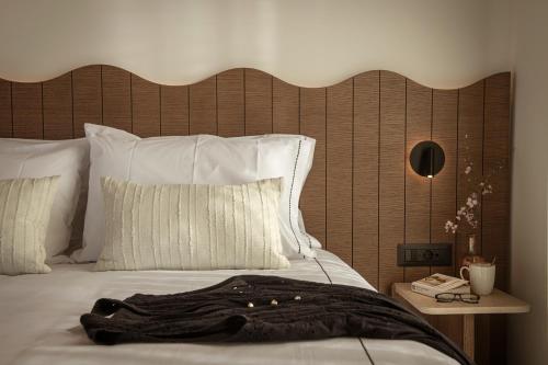 a bed with a wooden headboard and a black robe on it at Abas Villas in Paránimfoi