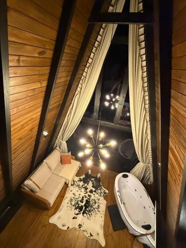 an attic room with a tub and a couch at Cabanas Girassol in Venda Nova do Imigrante