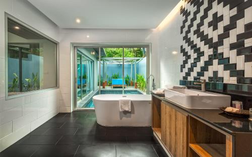 a bathroom with a large tub and a sink at Villa Sonata Phuket in Chalong 