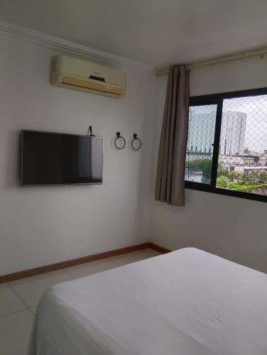 a bedroom with a bed and a flat screen tv at Hotel Centro de Manaus próximo ao Teatro Amazonas in Manaus