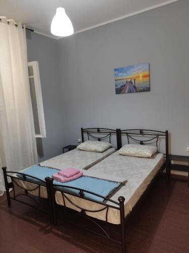 two twin beds in a room with at comfortable room and shared kitchen and bathroom in Athens
