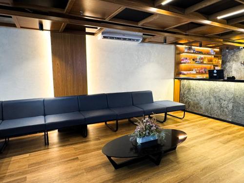 a living room with a blue couch and a table at Arrey Express Hotel - Teresina in Teresina