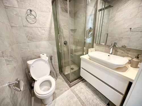 a bathroom with a toilet and a sink and a shower at Luxurious Orchid Apartment in Bijilo