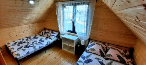 a small room with a bed and a window at DOMKI U STRAŻAKA GĄSKI -MORZE in Gąski