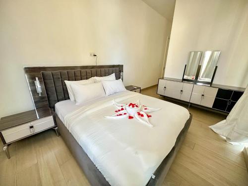 a bedroom with a large bed with two flowers on it at Luxurious Orchid Apartment in Bijilo